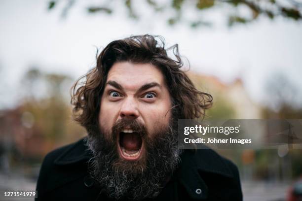 bearded man making faces outdoors - loud man imagens e fotografias de stock