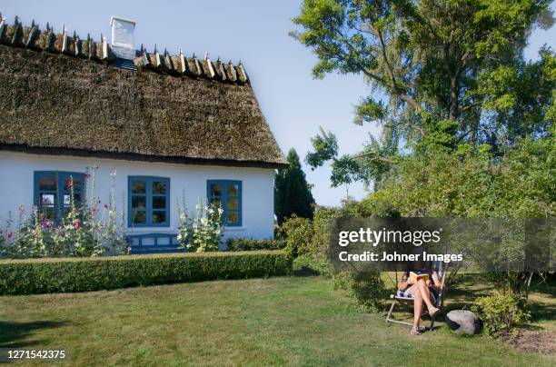 woman relaxing in garden - かやぶき屋根 ストックフォトと画像