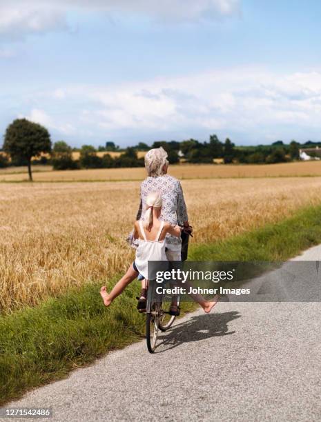 grandmother cycling with granddaughter - summer denmark stock pictures, royalty-free photos & images