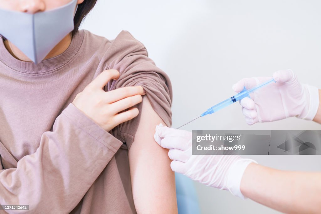 Corona virus vaccine injection to young woman