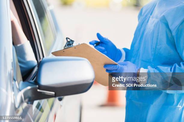 無法識別的護士在開車通過測試現場從患者那裡獲取資訊。 - test drive 個照片及圖片檔