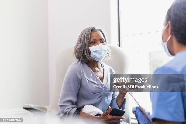 senior female patient talks with healthcare professional - hospital safety stock pictures, royalty-free photos & images