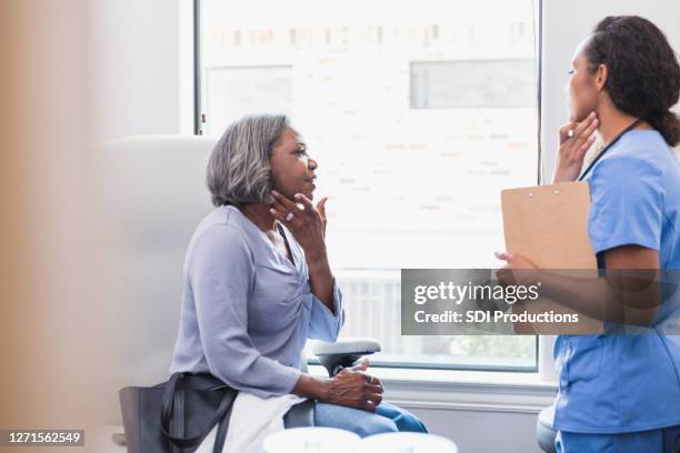 la femme aînée parle avec le dermatologue - irritation cutanée photos et images de collection