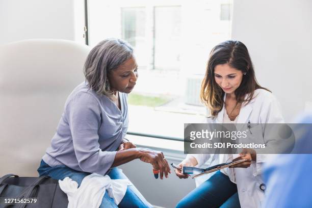 doctor discusses care options with patient - blank pamphlet stock pictures, royalty-free photos & images