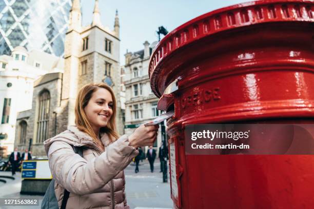 woman in london posting letter in public mailbox - mail box stock pictures, royalty-free photos & images