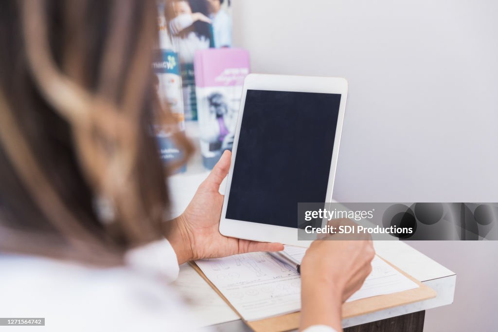 Unrecognizable doctor using digital tablet