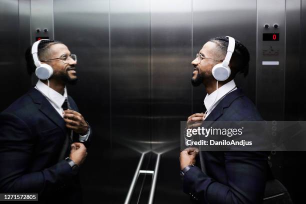 young entrepreneur ties his tie in front of the mirror - man with cravat stock pictures, royalty-free photos & images