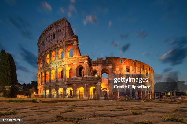 coliseo en roma por la noche con las luces encendidas - coliseo romano fotografías e imágenes de stock