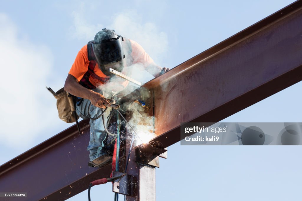 Hispanic ironworker welding a steel girder