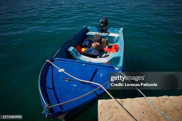 Some boats are moored after being used by migrants coming from Tunisia which just landed at the port on August 30, 2020 in Lampedusa, Italy....