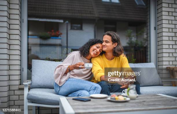 mãe hispânica e filho bebendo café ao ar livre juntos - coffee on patio - fotografias e filmes do acervo