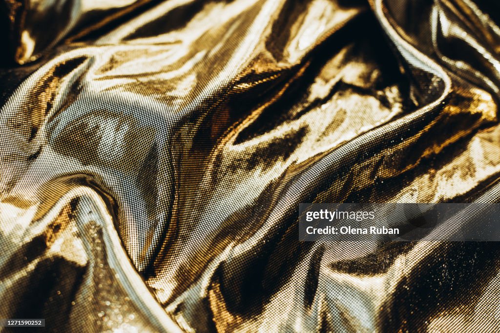 Golden shiny fabric beautifully crumpled