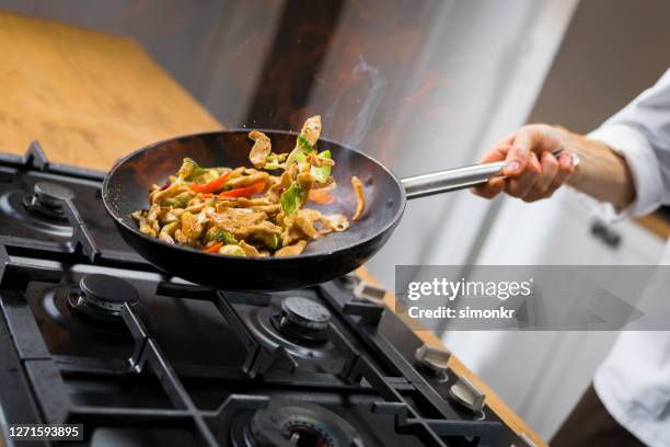 chef-kok die groenten in pan kookt - pan keukengereedschap stockfoto's en -beelden