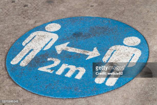 social distancing sign on the ground - social distancing stock pictures, royalty-free photos & images
