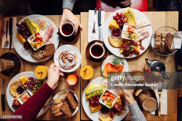 group of friends having celebration dinner together, directly above view - brunch imagens e fotografias de stock