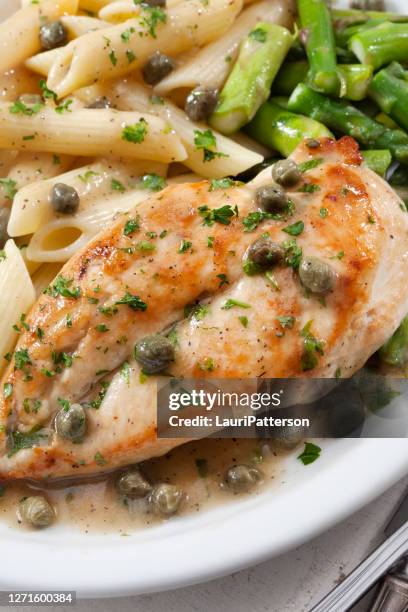 grilled chicken piccata with penne pasta and asparagus - chicken penne stock pictures, royalty-free photos & images
