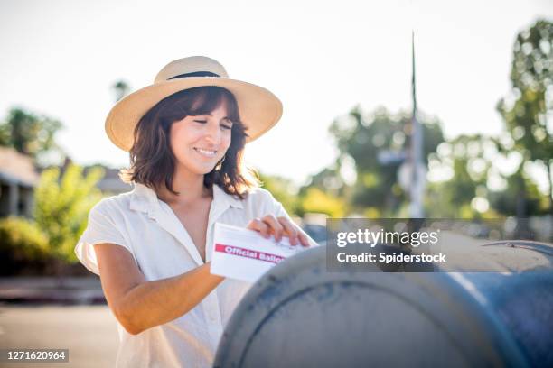 vrouw die haar afwezige stembus van de kiezer mailt - voting by mail stockfoto's en -beelden