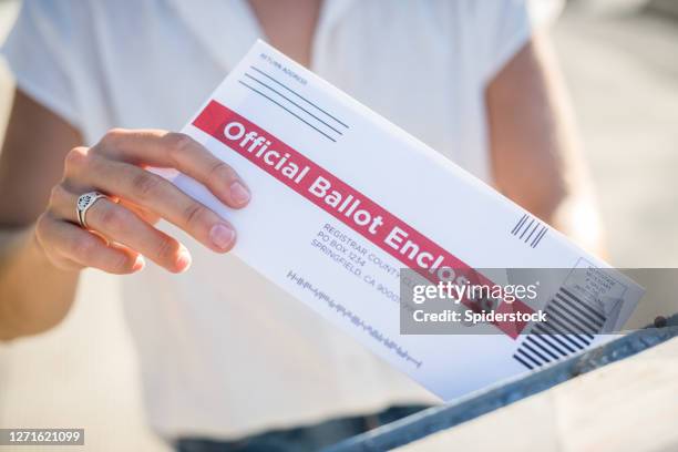 mujer enviando por correo su boleta de elector ausente - voto a distancia fotografías e imágenes de stock