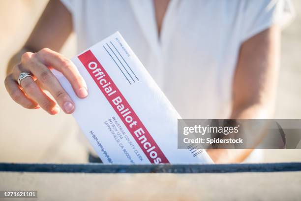 婦女郵寄她的缺席選民選票。 - voting ballot 個照片及圖片檔