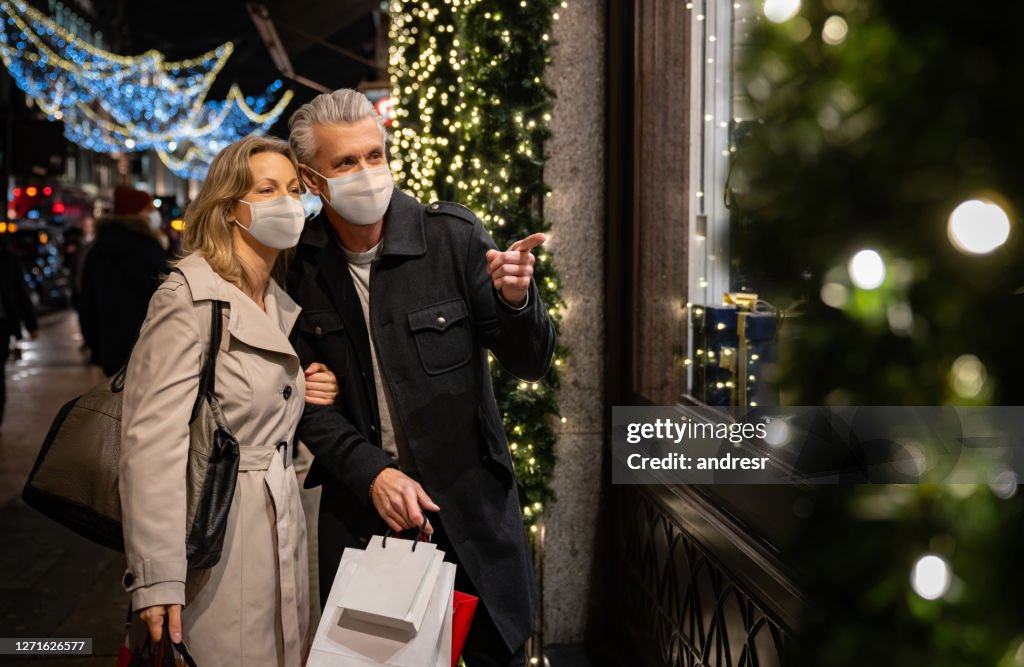 Couple Christmas shopping wearing a facemask in London