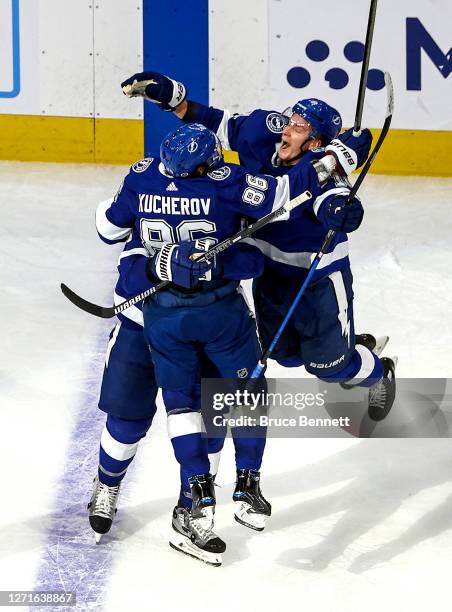 Nikita Kucherov of the Tampa Bay Lightning is congratulated by his teammates Ondrej Palat and Barclay Goodrow after scoring a goal in the final...