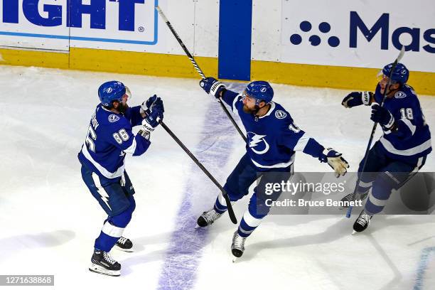 Nikita Kucherov of the Tampa Bay Lightning is congratulated by his teammates Ondrej Palat and Barclay Goodrow after scoring a goal in the final...