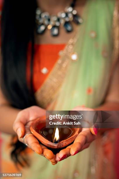 young indian woman holding diwali oil lamp - diya oil lamp stock pictures, royalty-free photos & images