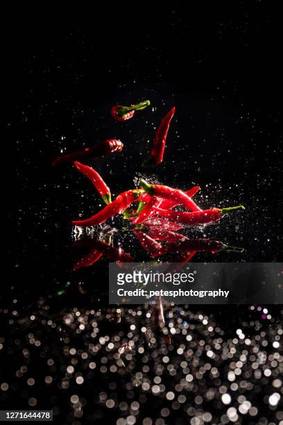 rode hete spaanse pepers die in water spatten - pepper spray stockfoto's en -beelden