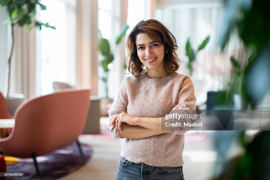 Portrait of smiling female entrepreneur standing at workplace