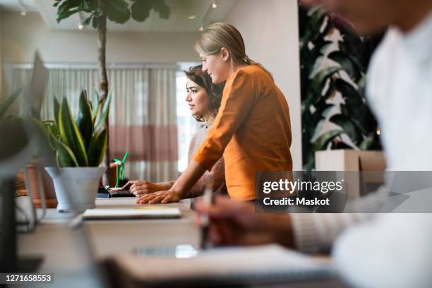 female business people working at table in office - coworking fotografías e imágenes de stock