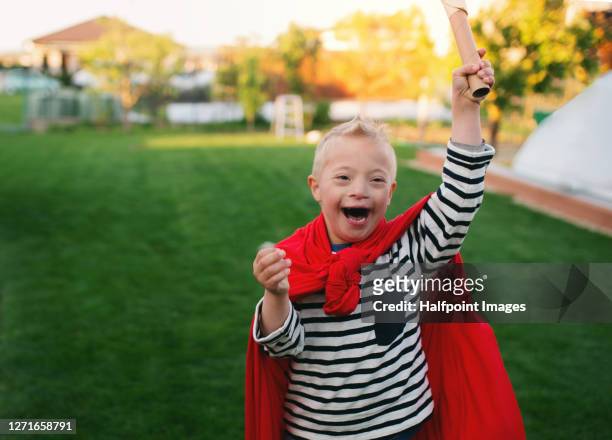 boy with down syndrome playing outdoors in garden. - knight person stock pictures, royalty-free photos & images