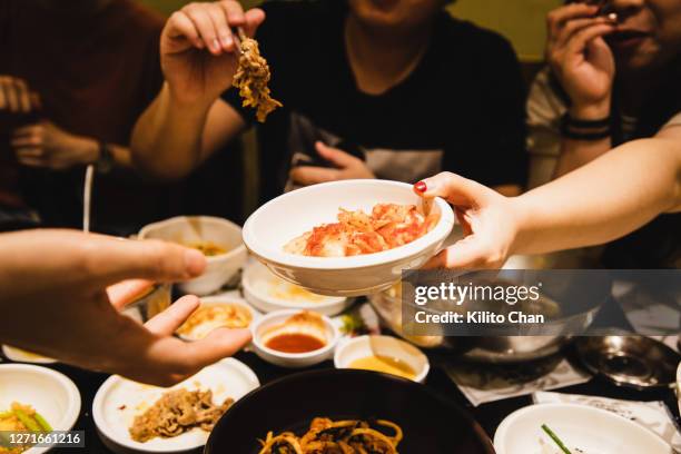 friends sharing korean food together - bowls of side dishes roast fotografías e imágenes de stock