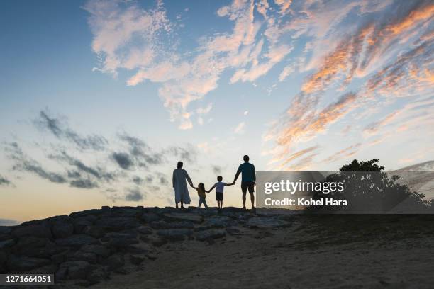 family relaxed in the beach at dusk - expectativas fotografías e imágenes de stock