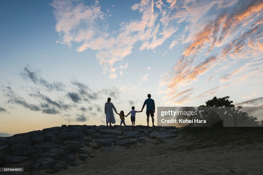 Family relaxed in the beach at dusk
