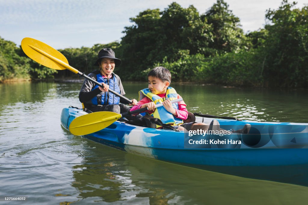 Mother and son enjoying kayaking in the river