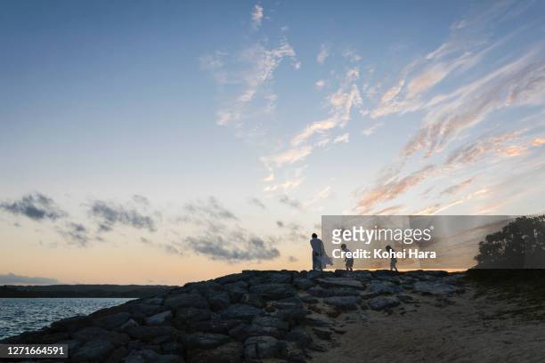 family relaxed in the beach at dusk - okinawa islands stock pictures, royalty-free photos & images