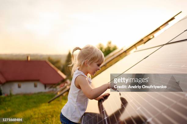 young girl touching solar panel. - energie industrie stockfoto's en -beelden