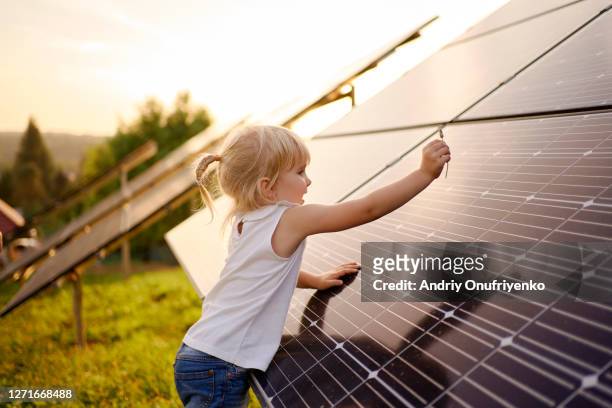 young girl touching solar panel. - solar energy bildbanksfoton och bilder