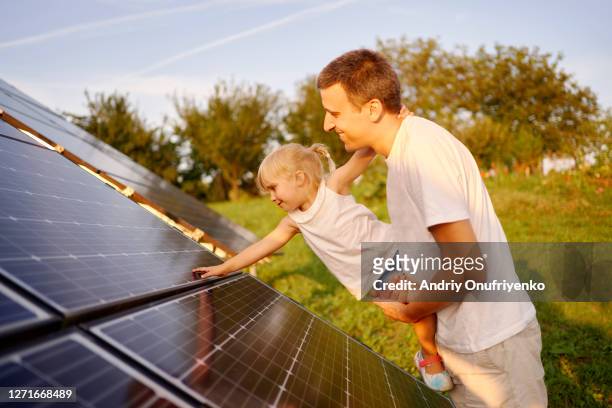 father and daughter touching solar panel - solar energy bildbanksfoton och bilder