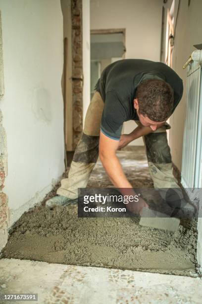 making a straight leveled ground, worker making new floor, using masons towel - leveled stock pictures, royalty-free photos & images
