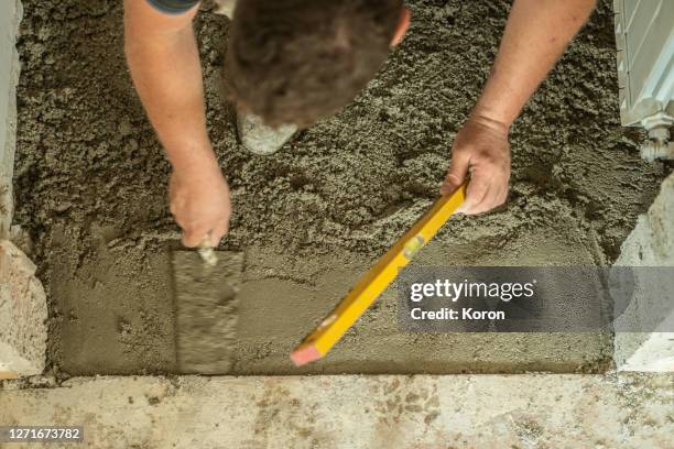 making a straight leveled ground, worker making new floor, using masons towel - leveled stock pictures, royalty-free photos & images