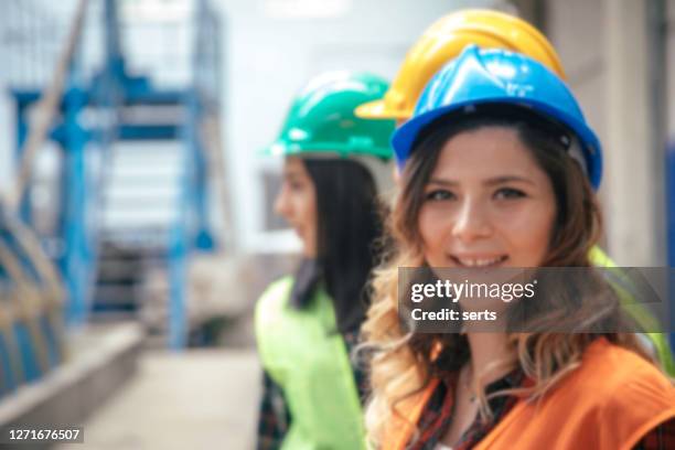 het onttondschot van de onscherpte van industriële machines twee vrouwenwerknemer die in fabrieksmagazijn werkt - werk in uitvoering stockfoto's en -beelden