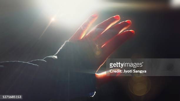 blocking sunrays coming through the window,  a hand shot of covering sunbeam. - sun rays through window stock pictures, royalty-free photos & images