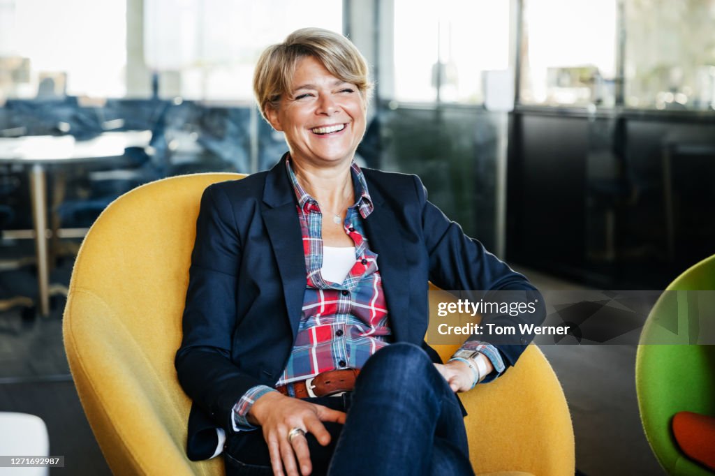 Office Manager Sitting In Green Chair Smiling