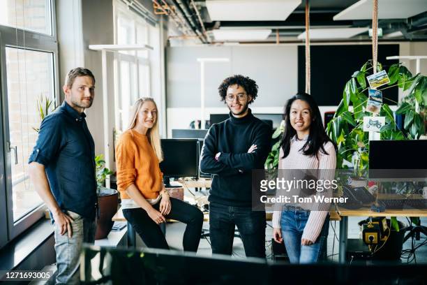 portrait of business team standing in modern office - four people stock-fotos und bilder