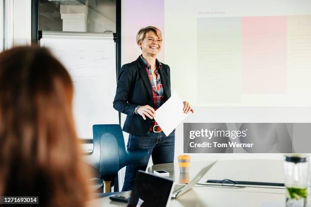 office manager addressing staff during meeting - woman short blond hair stock pictures, royalty-free photos & images