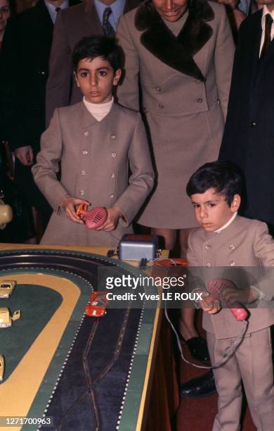 Les fils du Shah d'Iran Reza Pahlavi et Ali-Reza Pahlavi jouant avec un circuit de voitures électriques au salon du jouet, le 13 février 1970, à...