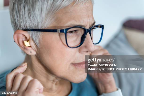 mature woman using earplugs for sleeping - woman ear plugs stock pictures, royalty-free photos & images