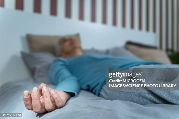 woman lying in bed meditating - mudra stock-fotos und bilder