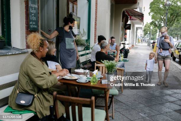 owner welcoming customers at reopened restaurant - berlin cafe fotografías e imágenes de stock